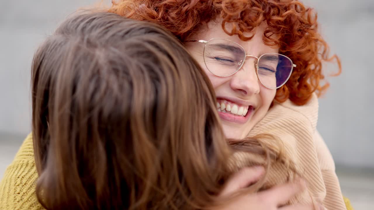 Happy meeting between two young friends in the street