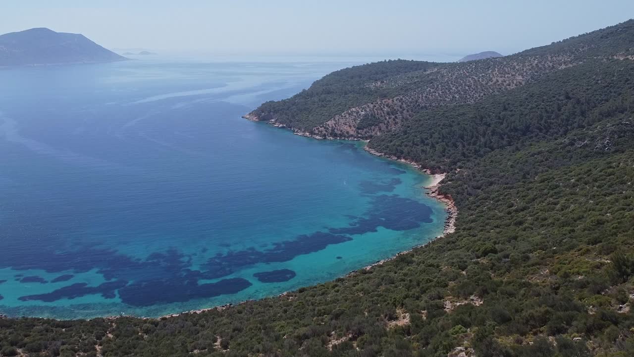 Aerial view of paradise beach of Firnaz Koyu with blue waters of Mediterranean Sea and mountains, Turkey