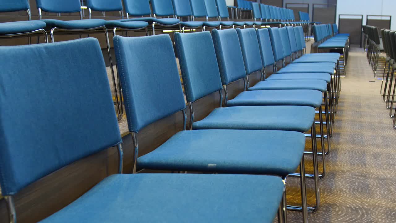sillas vacías azules en una fila en la sala de conferencias