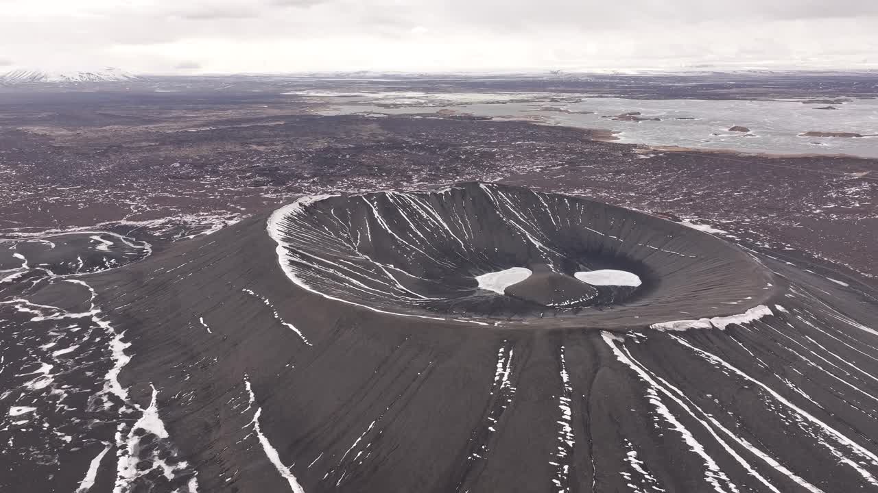 Lonely volcanic crater with snow lines in Iceland’s Mývatn area, aerial winter view
