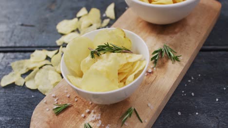 Close-up-view-of-two-bowls-of-potato-chips-on-wooden-tray-with-copy-space-on-wooden-surface