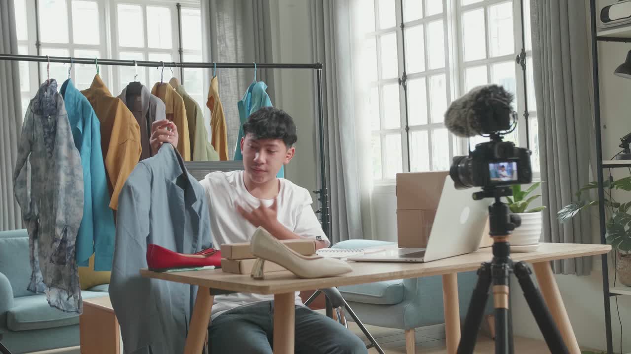Asian Man Online Seller Recommending A Shirt And Recording Video By Camera While Using Computer For Selling Clothes At Home