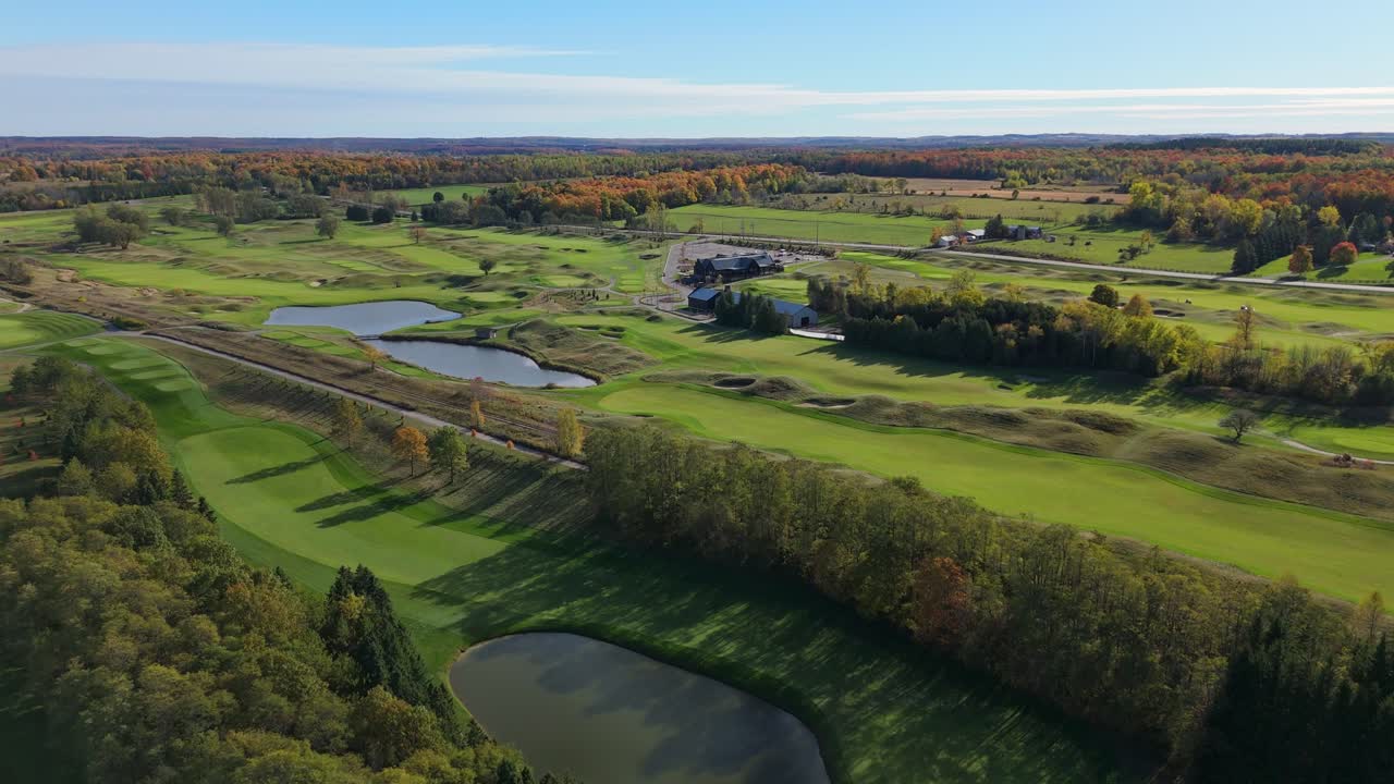 A high-angle aerial view of the TPC Toronto at Osprey Valley, showcasing its challenging, links-style layout with rolling fescue, water hazards, and pristine greens in peak autumn