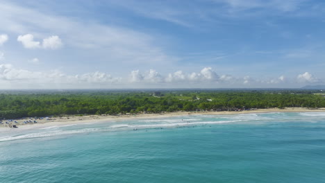 Serenas-Aguas-Azules-Con-Surfistas-En-Bávaro-Beach-Resort,-Punta-Cana,-República-Dominicana