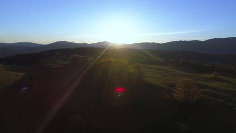 epic sunrise behind jura mountains during blue sky and red lens flares