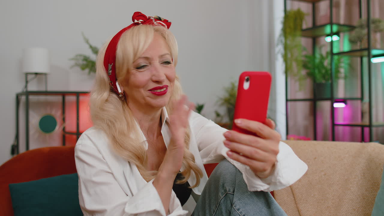 abuela mayor mujer haciendo una llamada de conversación telefónica con la familia sentada en el sofá en casa en la habitación