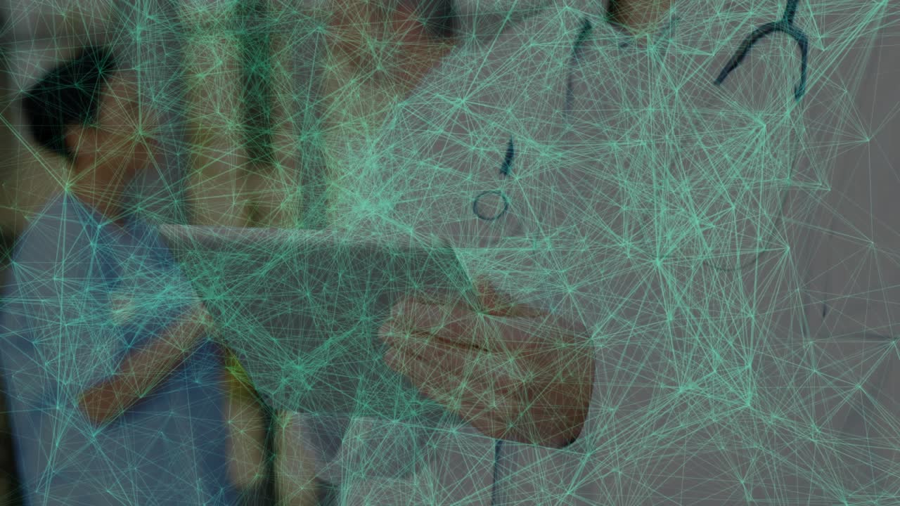 Male doctor responding to pulsing network overlay by tapping tablet and viewing records in lobby