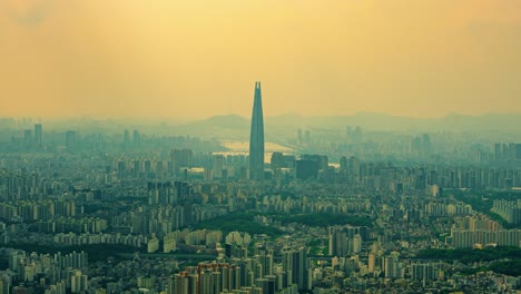 a timelapse with a slow zoom-in effect focuses on the iconic lotte world tower, which rises through a thick layer of yellow haze or air pollution covering the city of seoul.