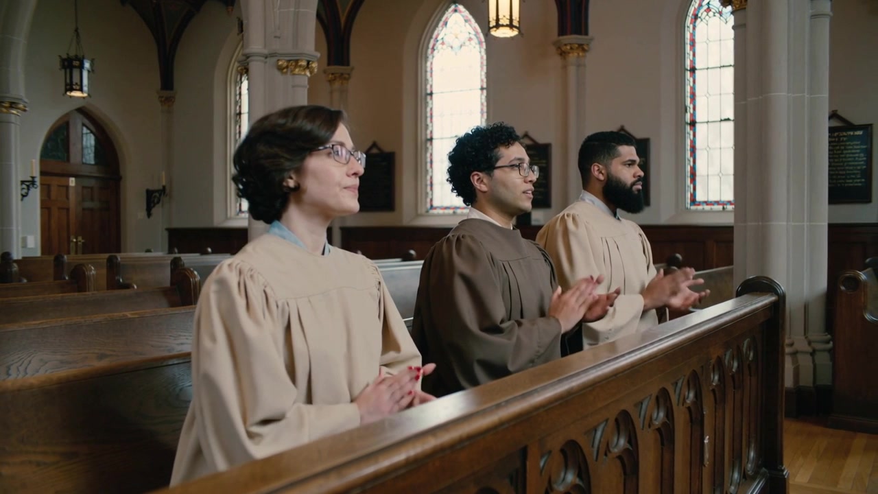 Clapping three choir members joining worship as music starting in church, wearing choir robes