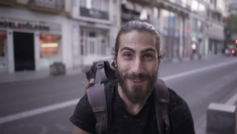 man with backpack in city street
