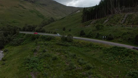 Profile-drone-shot-over-cars-driving-in-the-scottish-countryside