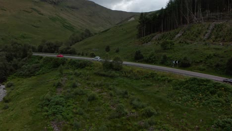 profile drone shot over cars driving in the scottish countryside