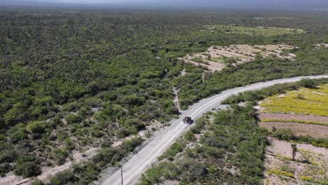 conducción de automóviles rápido a través de terrenos baldíos dejando rastro de polvo detrás