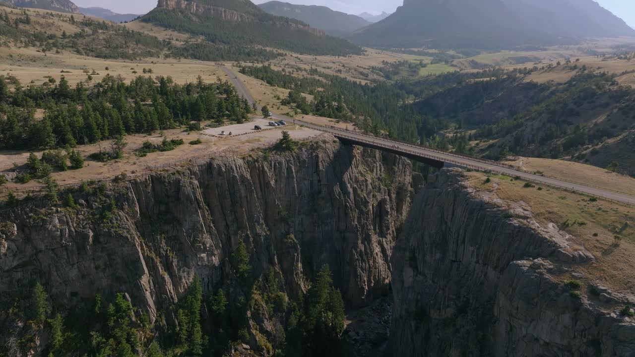 Aerial orbit rising above Sunlight Creek Bridge in Wyoming, showcasing the steep canyon walls and the expansive Wyoming landscape