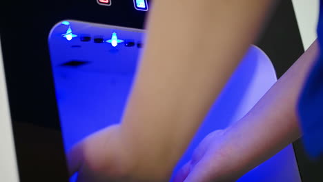 woman cleaning hands in sterilizing machine