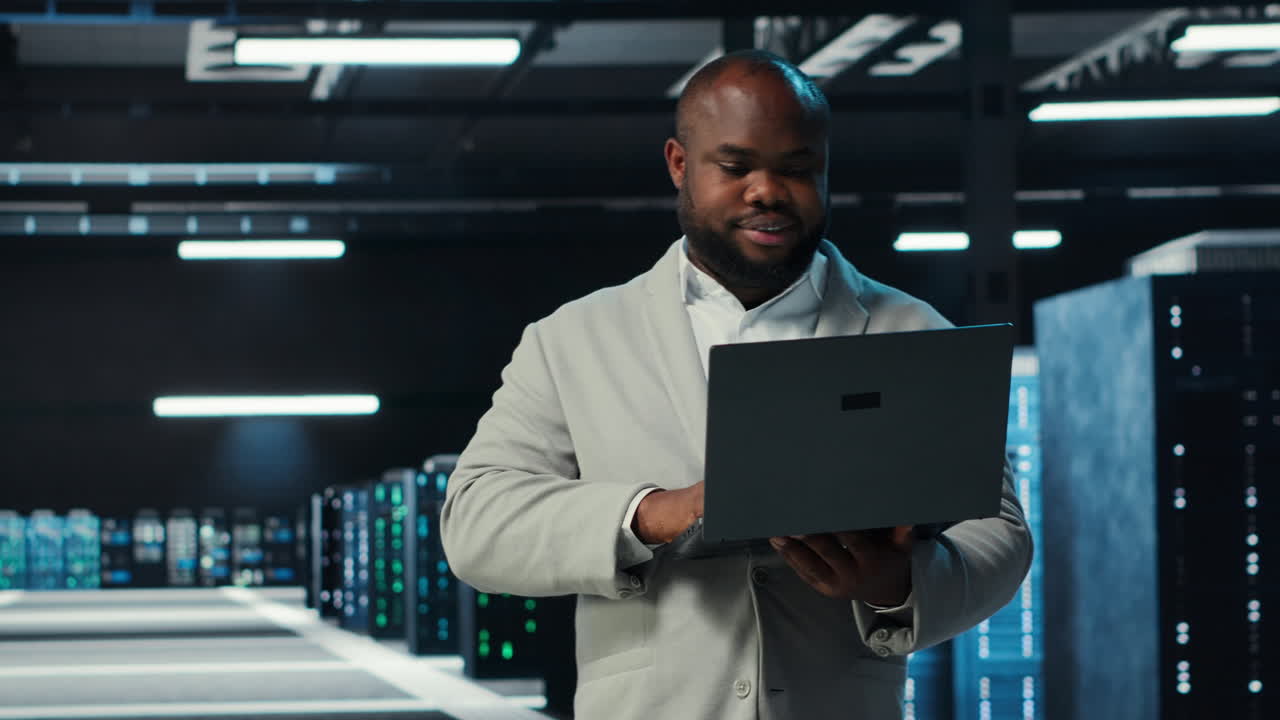 Vertical video Data center engineer coding on laptop, doing software updates for mainframes