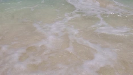 Crystal-clear-sea-water-wave-crash-on-white-sand-with-splash-foam,-froth-texture