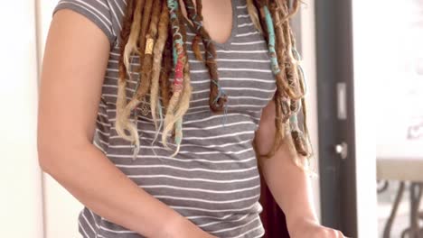 woman with dreadlocks slicing strawberry