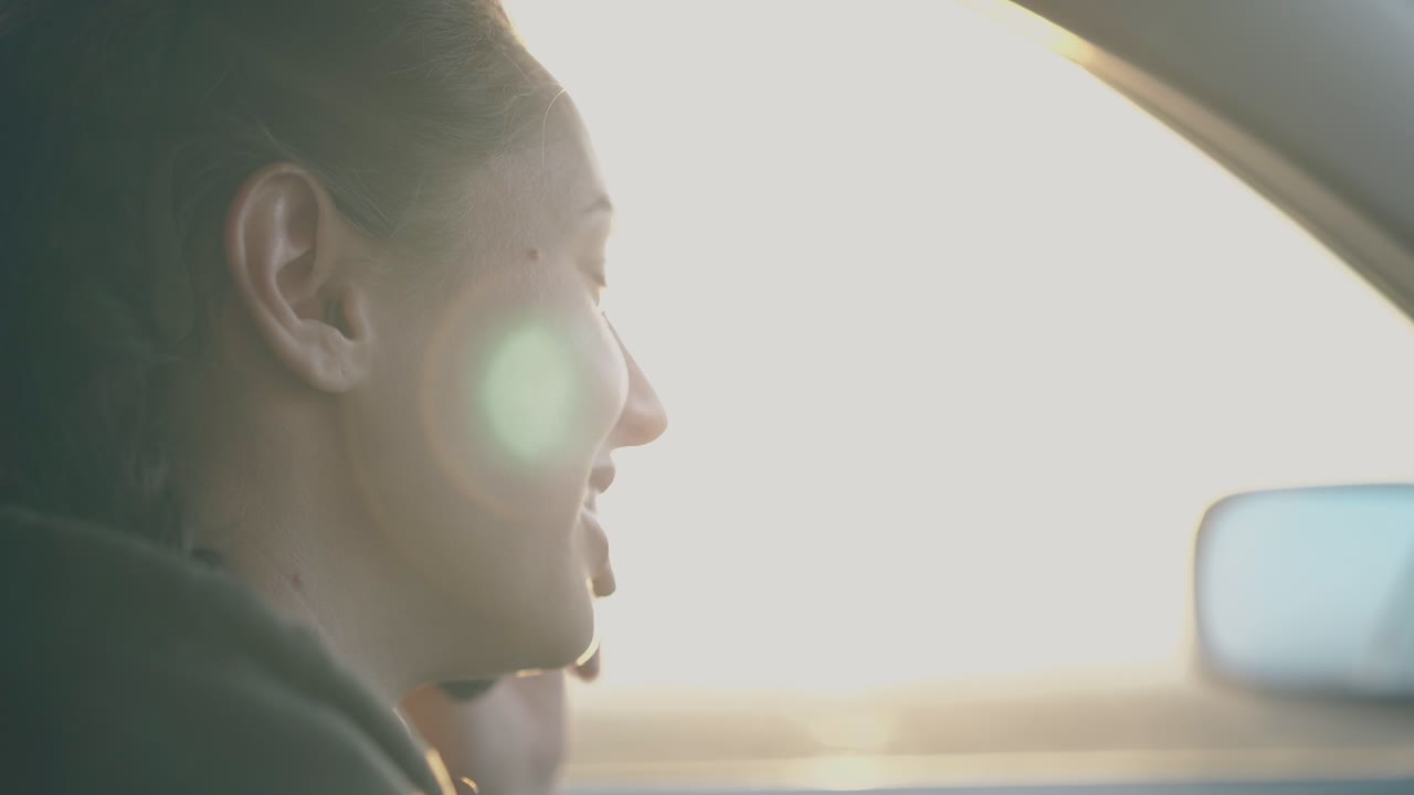 어두운 머리카락을 가진 행복한 여성이 전화로 웃고 웃고 있습니다.