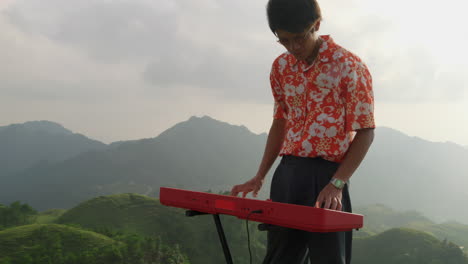 Right-to-left-sweeping-pan-of-a-man-playing-the-piano-on-a-mountaintop