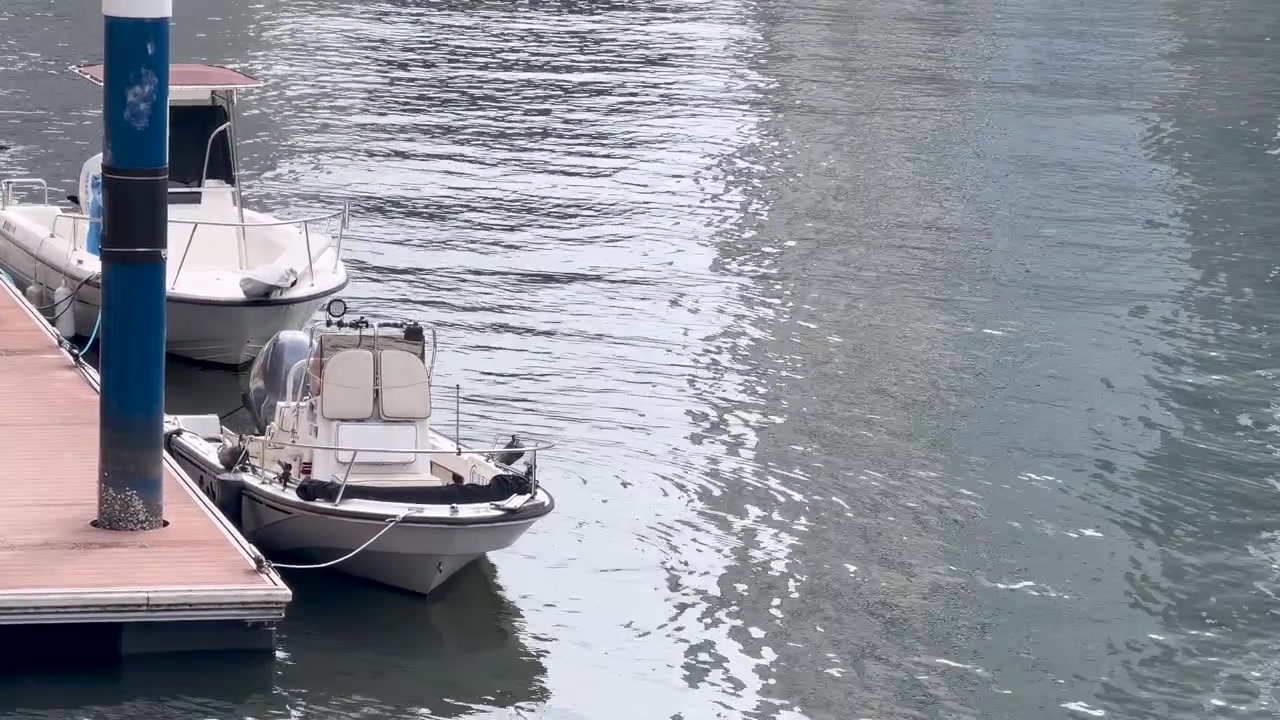 Piccole barche a motore ormeggiate a un pontile galleggiante in un porto turistico