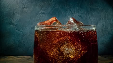 cola with ice and bubbles in glass.