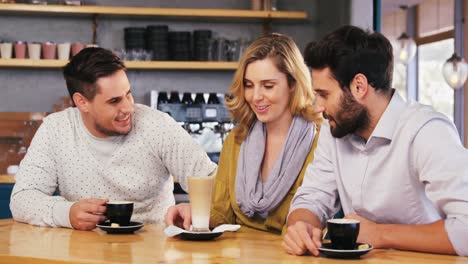 Amigos-Interactuando-Mientras-Toman-Una-Taza-De-Café