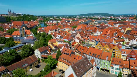 4k aerial drone video of the beautiful homes and churches along the regnitz river in the old town area of downtown bamberg, germany