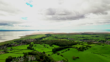 Vista-Aérea-De-Exuberantes-Tierras-De-Cultivo-Verdes-En-La-Costa-De-Inglaterra,-Sol-Brillante