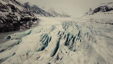 Lengua-Glaciar-En-Islandia-Filmada-Por-Drones-Con-Diferentes-Movimientos-Cinematográficos,-Mostrando-Un-Concepto-Turbio-Y-Dramático-En-Condiciones-Invernales