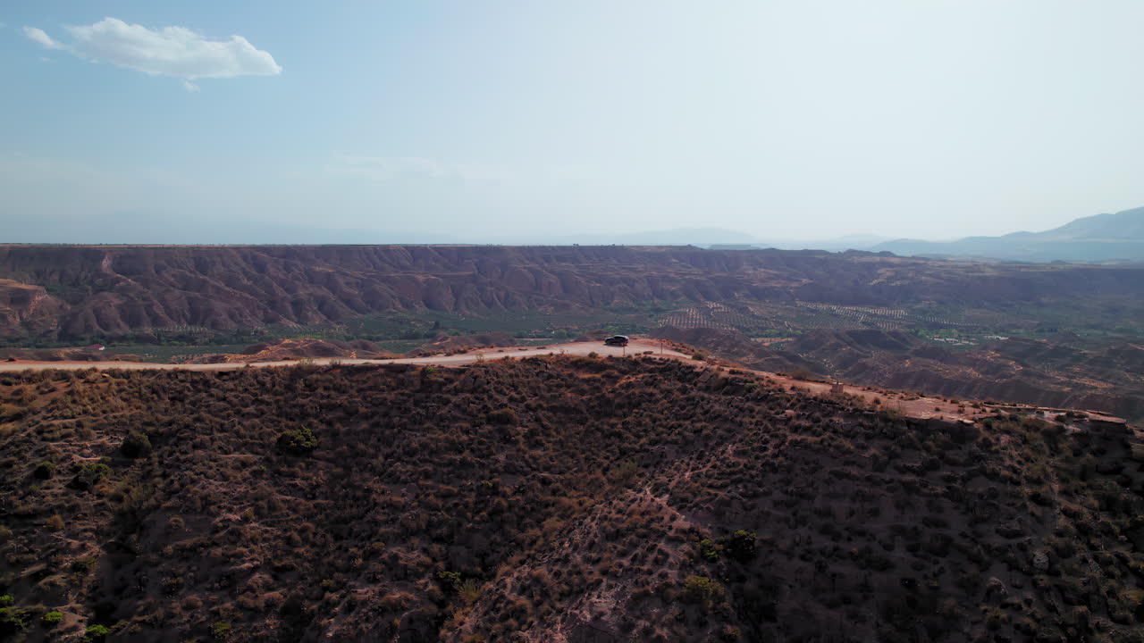 Ridge of Gorafe desert, aerial birdseye view with black suv standing on top of it