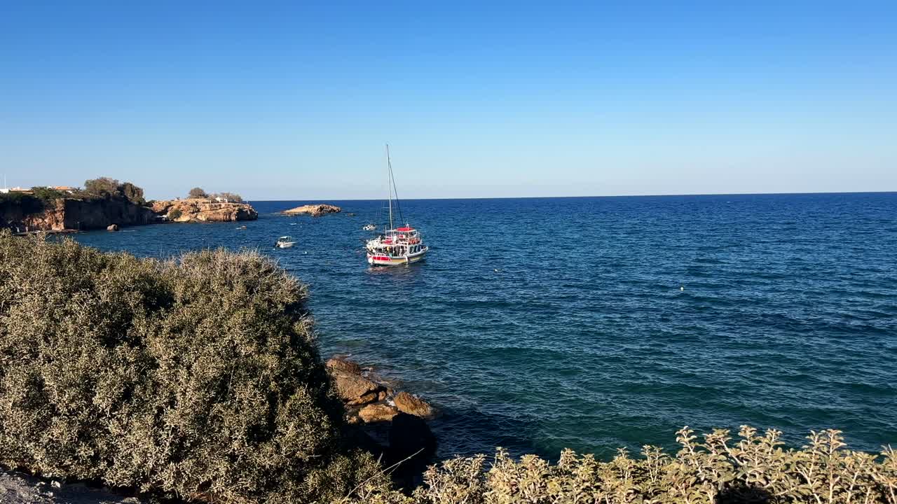 Coastal scene with a tourist boat at Hersonissos, Crete island, Greece