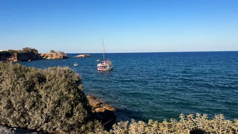 coastal scene with a tourist boat at hersonissos, crete island, greece