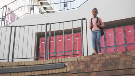 walking down stairs, african american girl with backpack in school, heading to class