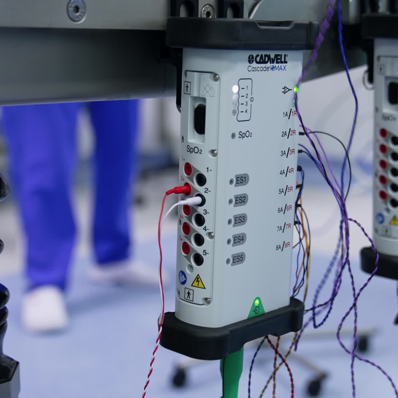Female hands switching on the electrodes into the slots. Setting the neurosurgical equipment for neuromonitoring. Close up