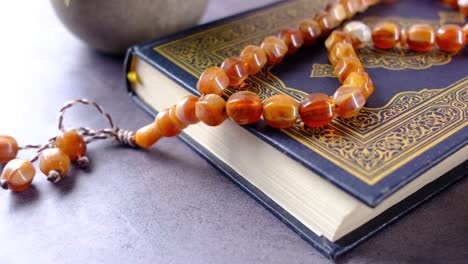 holy book quran and rosary on table, close up.