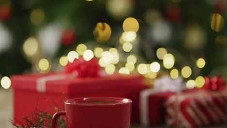 video of christmas gift and hot chocolate over christmas tree and lights