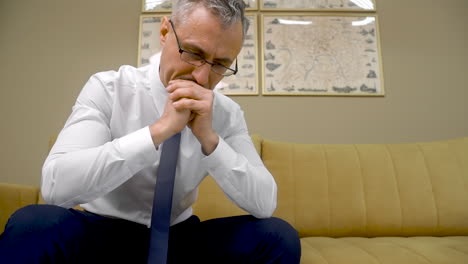 Confused-And-Angry-Male-Employee-Looking-Down-And-Gesturing-With-His-Hands-At-The-Office