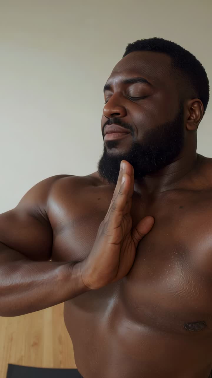 Video verticale: uomo a torso nudo che inspira e muove la mano dal petto all'addome per calmarsi a casa, sul pavimento