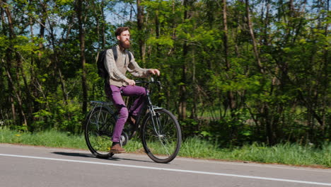 An-Attractive-Man-With-A-Beard-Rides-A-Bike-Along-A-Bicycle-Path