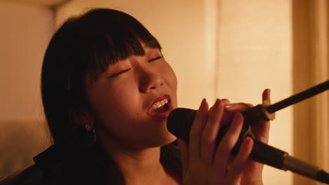 asian woman singing into a microphone