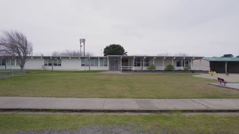 Pan-across-sidewalk-and-school-with-no-people-on-cloudy-day