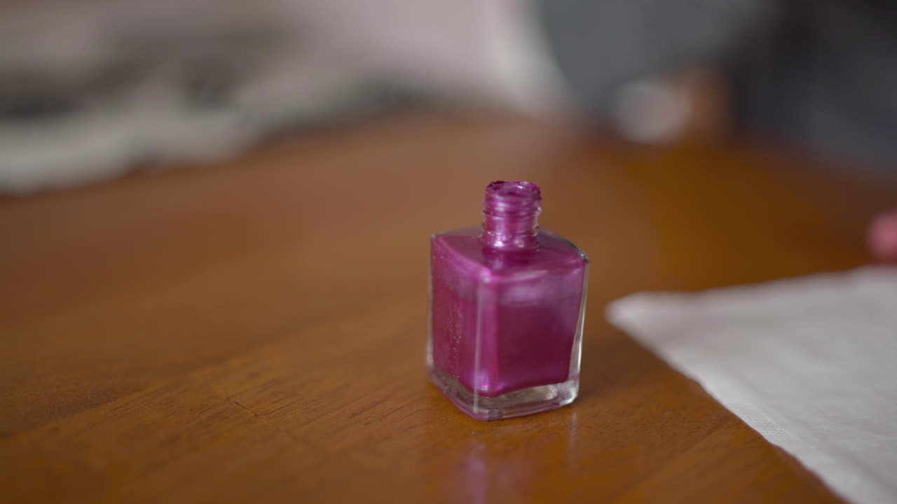 mujer se aplica esmalte de uñas en el dedo anular sobre una servilleta