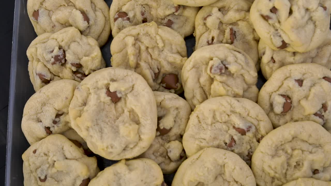 Tasty cooked chocolate chip cookies stacked and piled on pan ready to be eaten, directly above close up zoom in