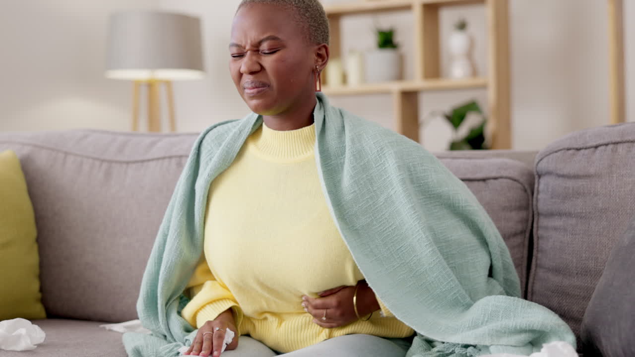 Black woman, sofa and stomach with cramps