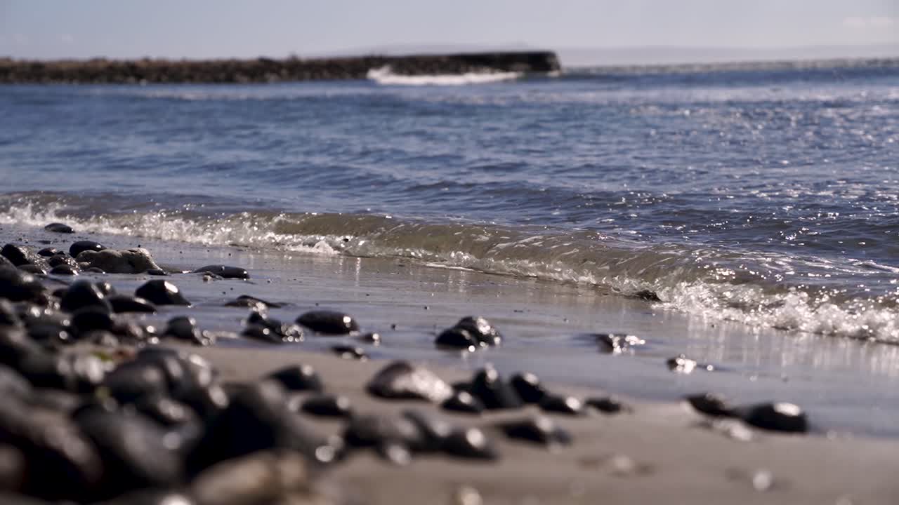 Small waves crashing on the sand beach slow motion