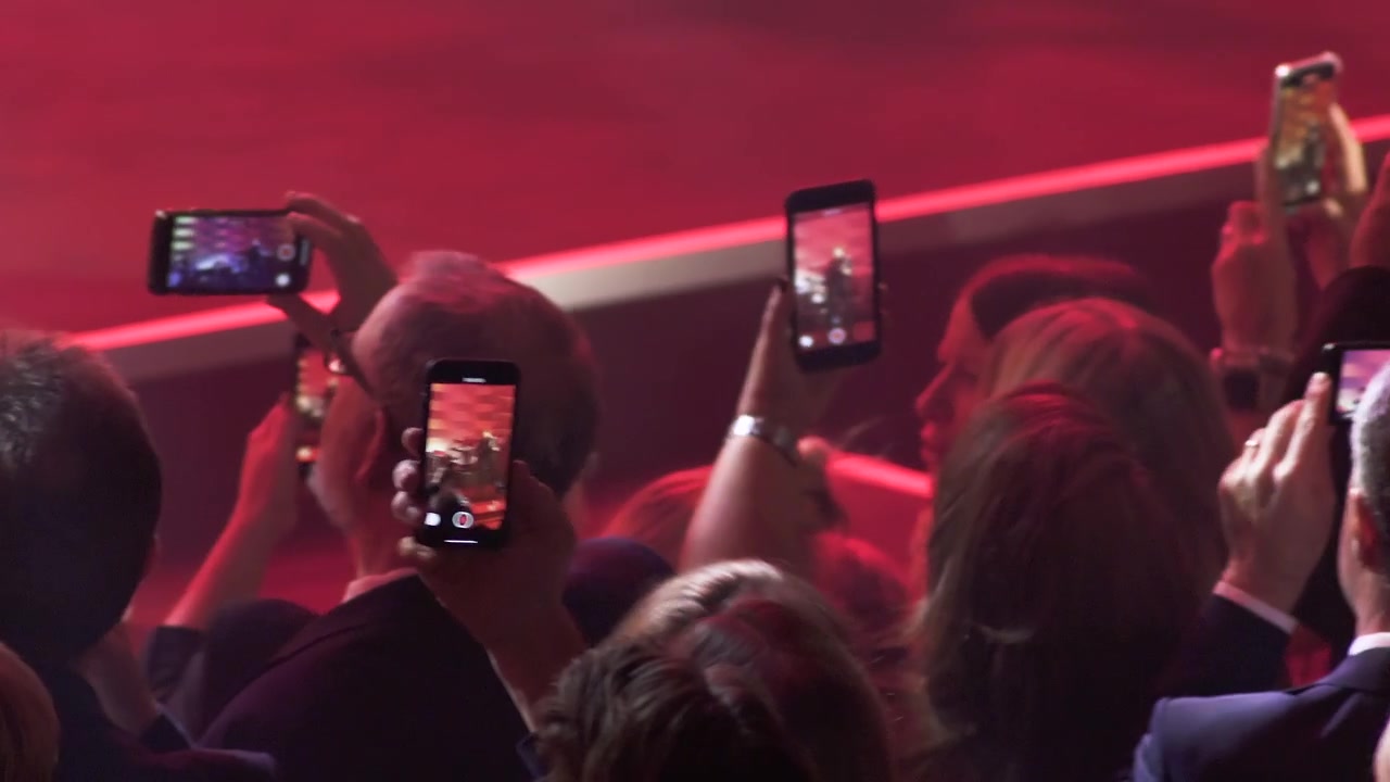 Concert crowds full of fans watching through cellphones.