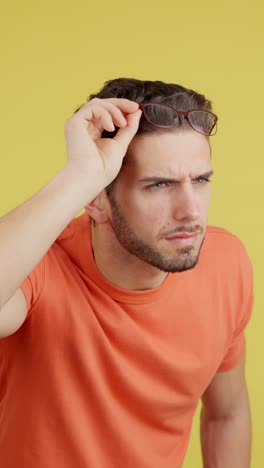 man adjusting and removing his glasses