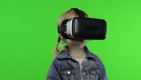 child girl using vr app helmet to play simulation game, drawing. watching virtual reality 3d video