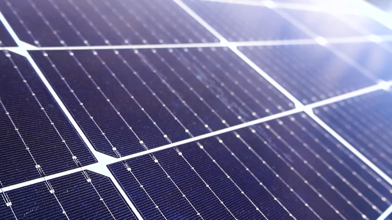 Vista dettagliata di celle fotovoltaiche su una superficie di pannello solare che riflettono il cielo e la luce solare, catturando energia rinnovabile, pulita e sostenibile per un futuro verde e la conservazione ambientale